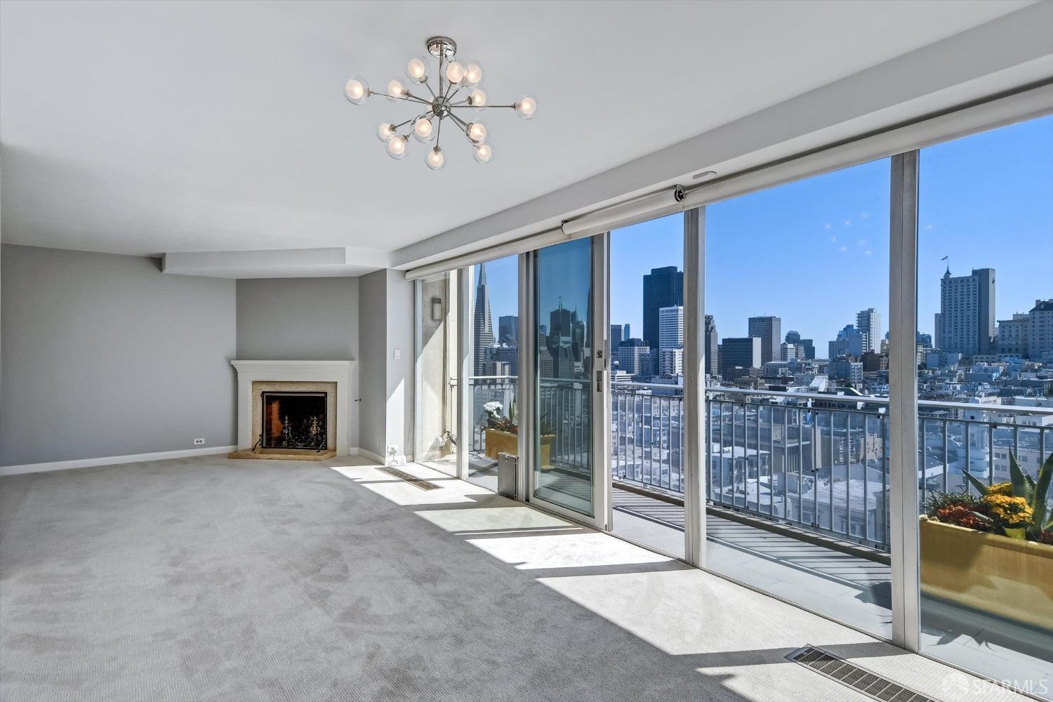 a view of a livingroom with a fireplace and balcony