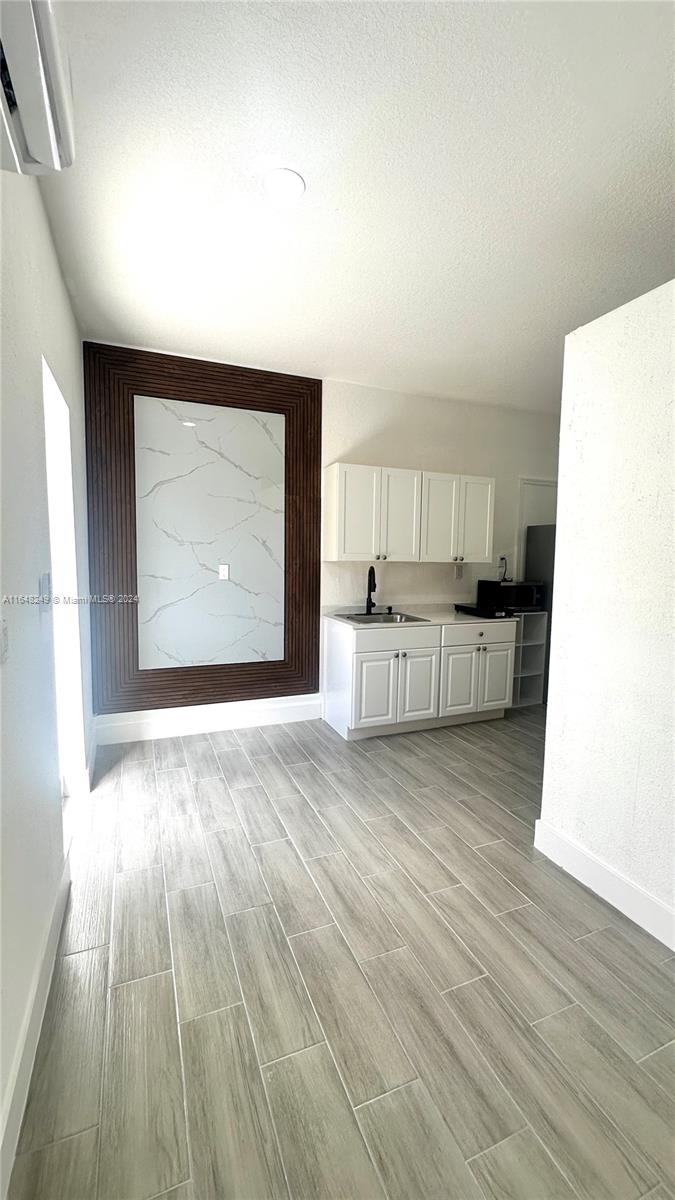 a view of a kitchen with furniture and wooden floor