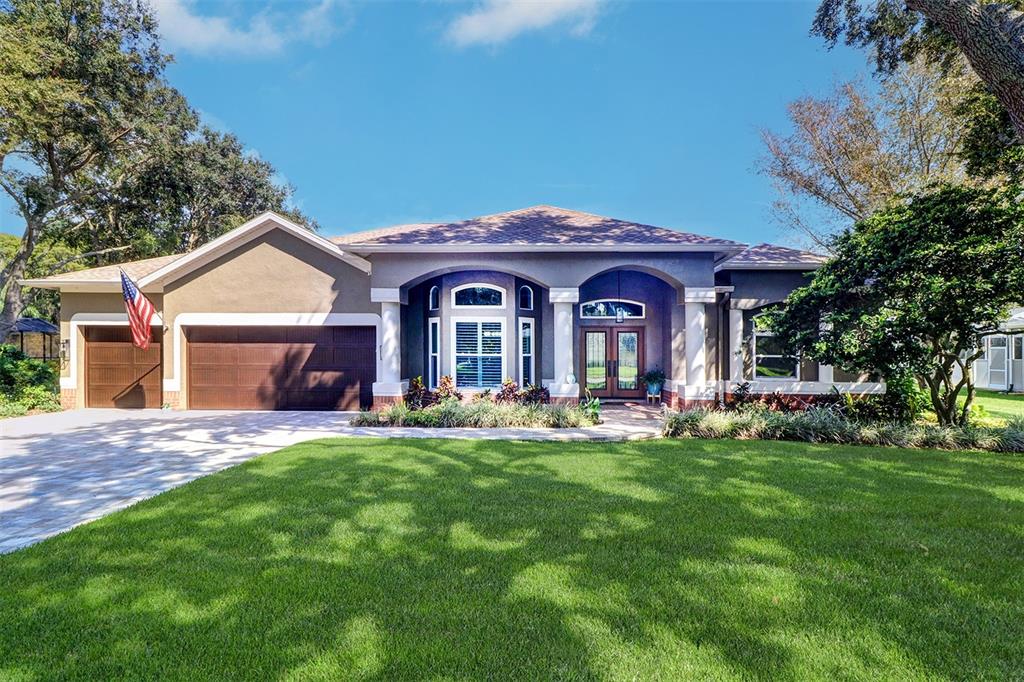 a front view of a house with yard and green space