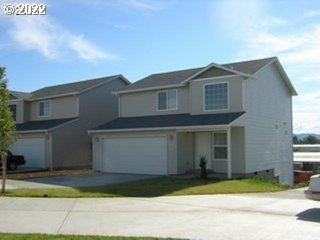 a front view of a house with a garden and garage