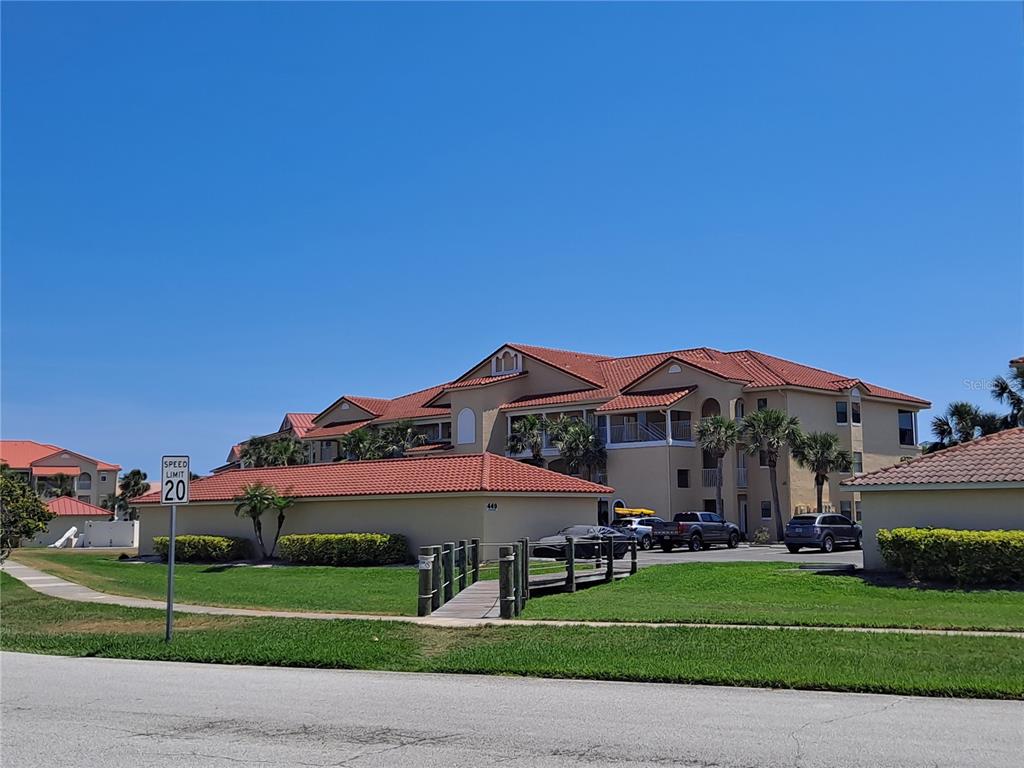 a view of a big house with a big yard and large trees