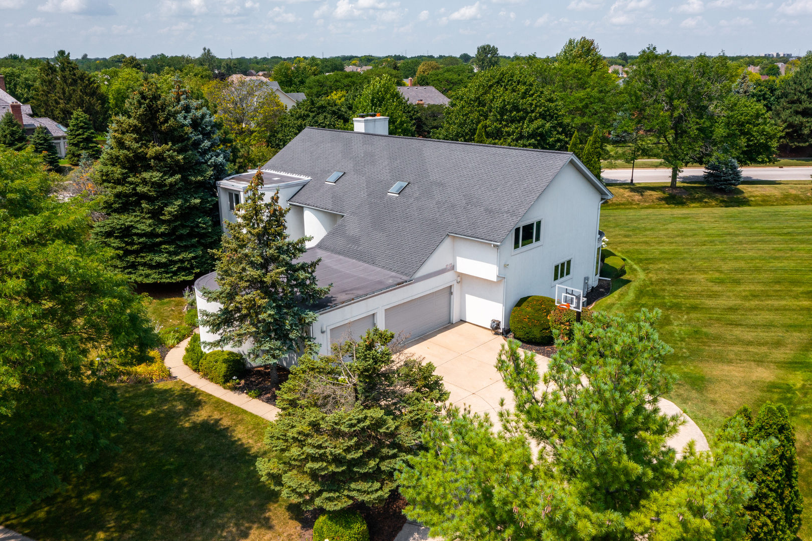 an aerial view of a house with a garden and lake view