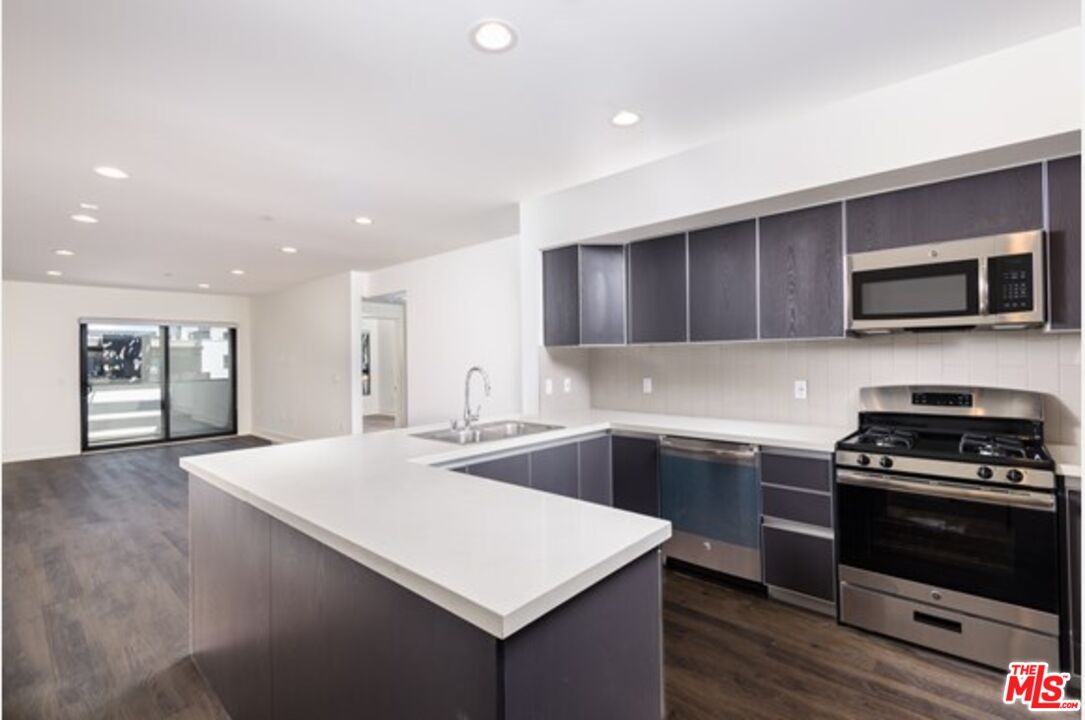 a kitchen with a sink cabinets and stainless steel appliances