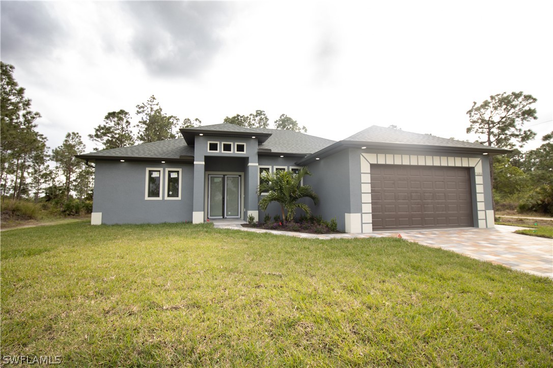 a view of a house with a yard and garage