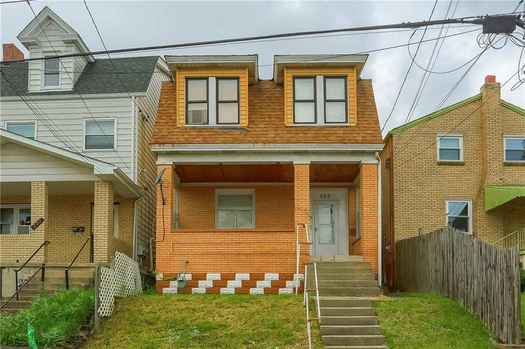 a view of a house with brick walls and a yard