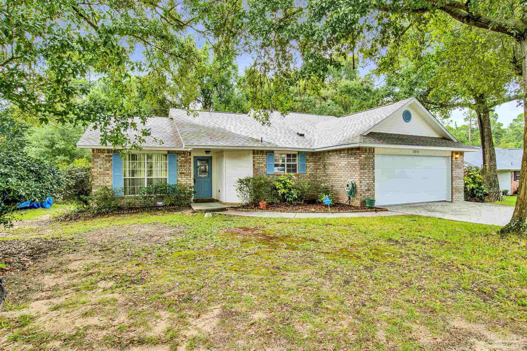 a front view of a house with a yard and trees