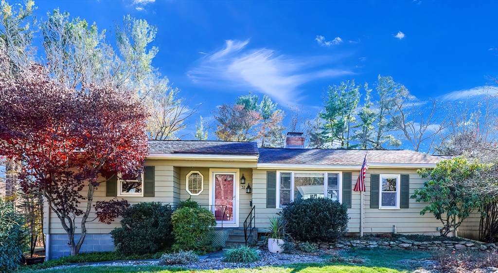 a front view of a house with yard porch and tree