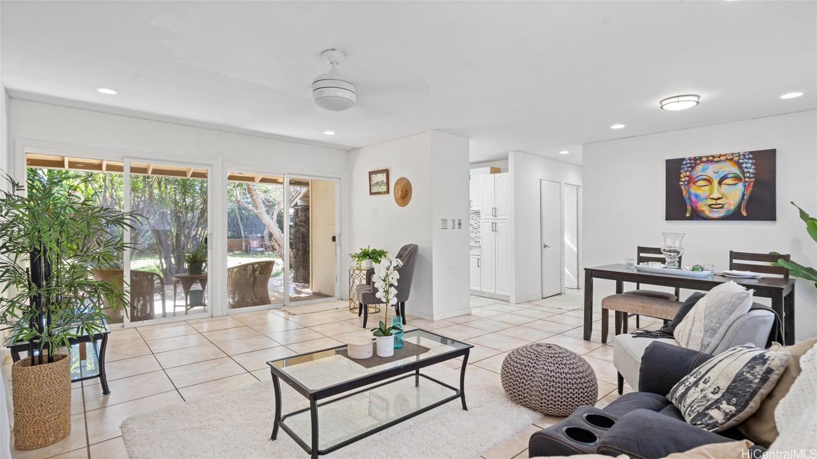 a living room with furniture a rug and a floor to ceiling window