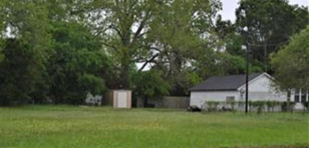 a front view of a house with a garden and trees