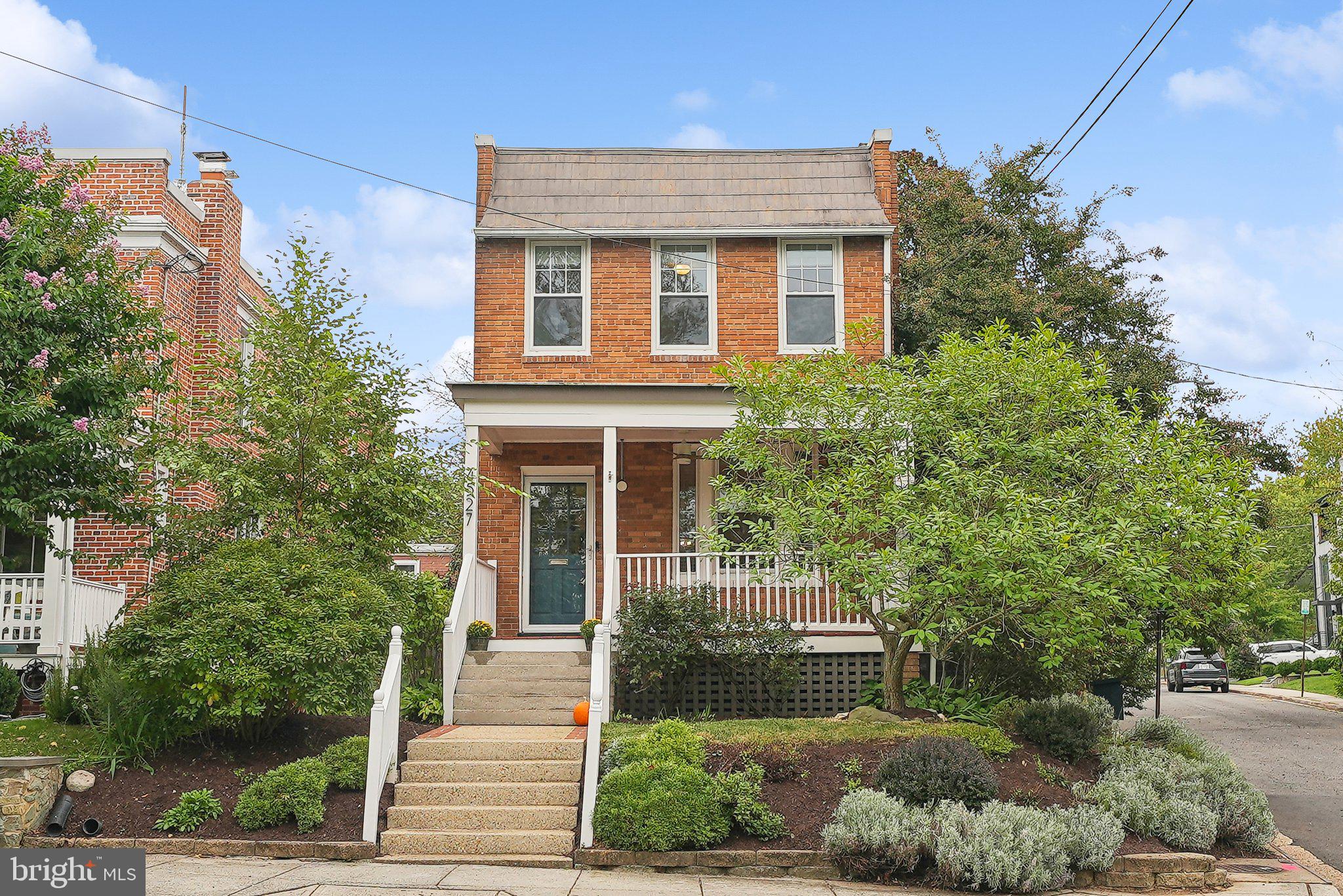 a front view of a house with plants and trees