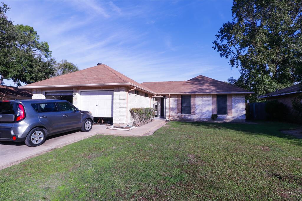 a front view of a house with a garden and tree