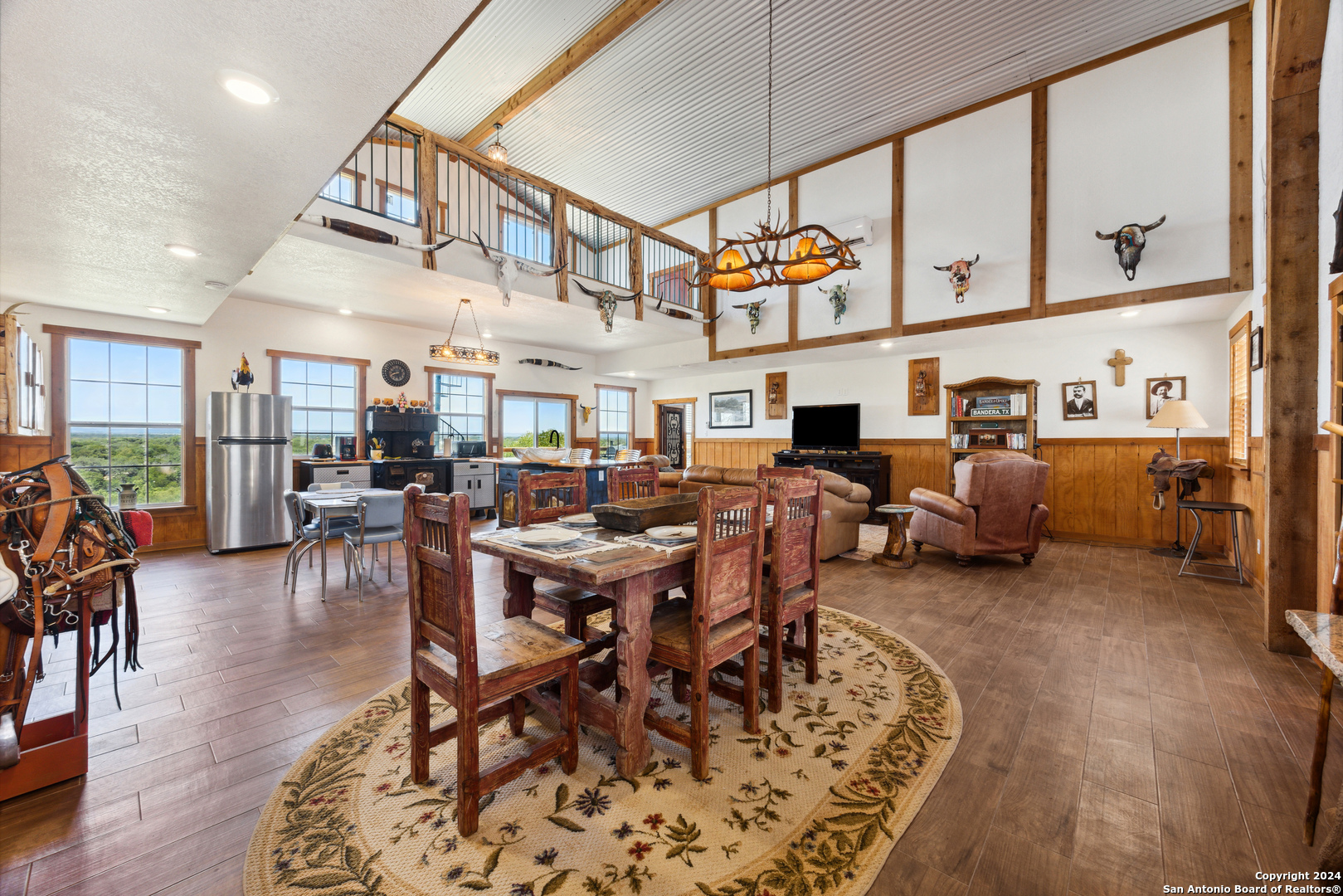 a living room with lots of furniture a rug appliances and a dining table