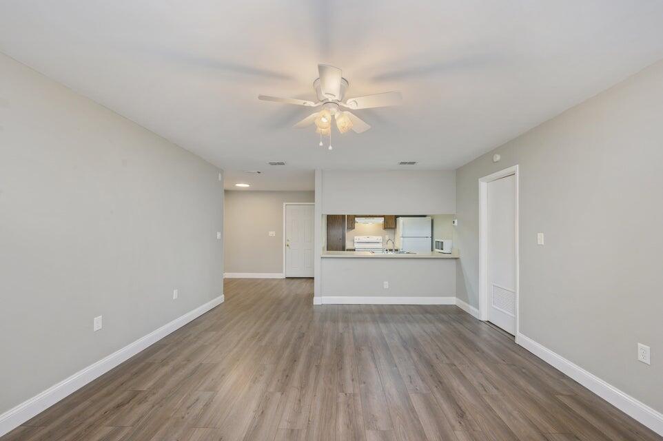 a view of a kitchen with wooden floor and a ceiling fan