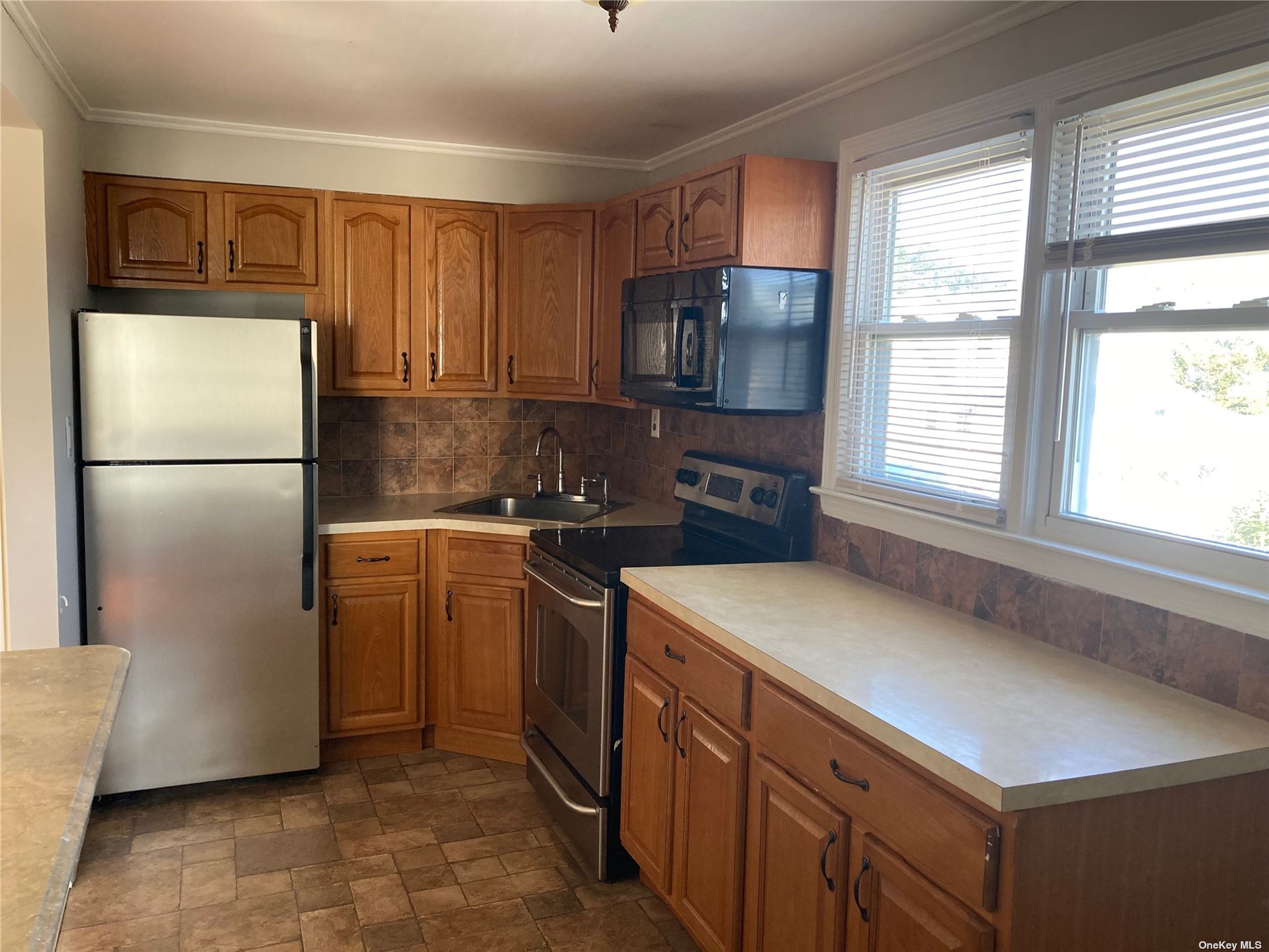 a kitchen with stainless steel appliances a refrigerator sink and microwave