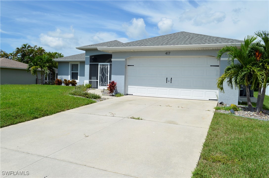 a front view of a house with a yard garage and outdoor seating