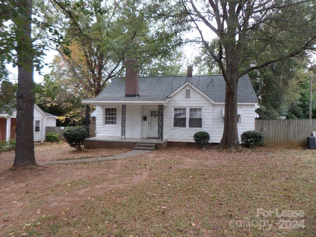 a front view of a house with a tree in it