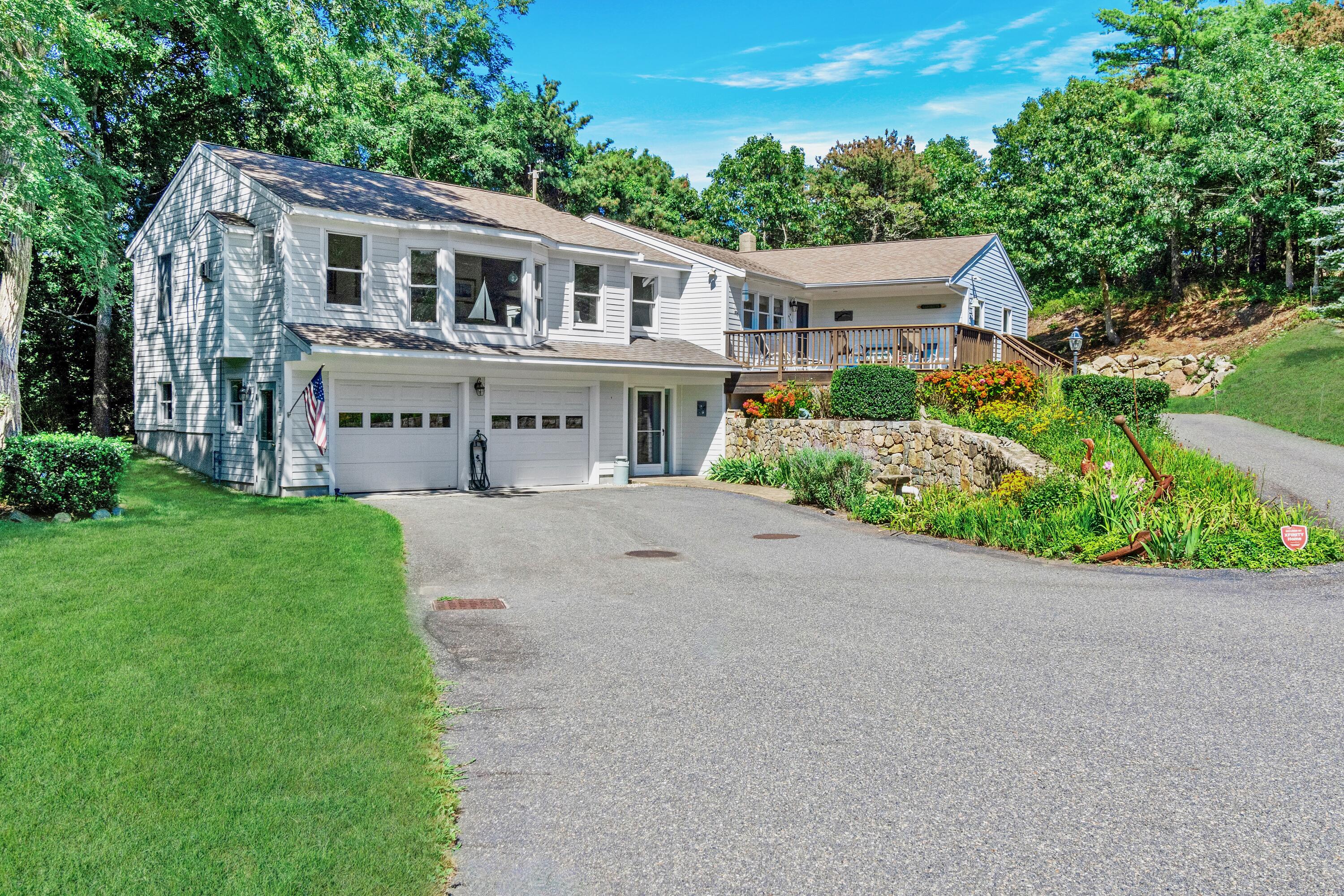 a front view of a house with a garden and trees