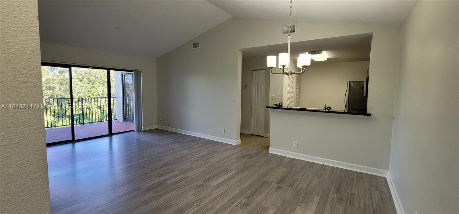 a view of a room with wooden floor and chandelier