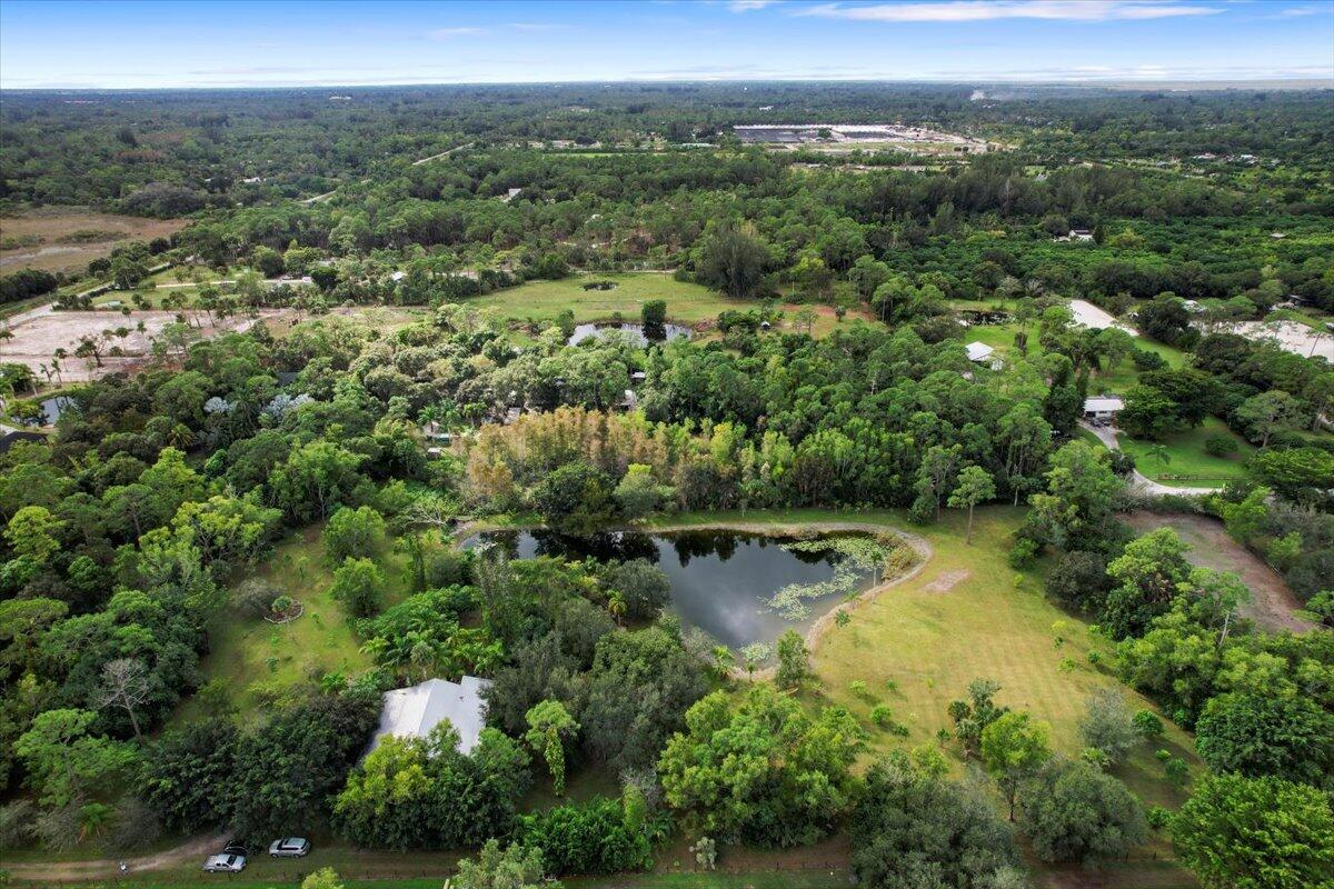 an aerial view of residential houses with outdoor space and trees