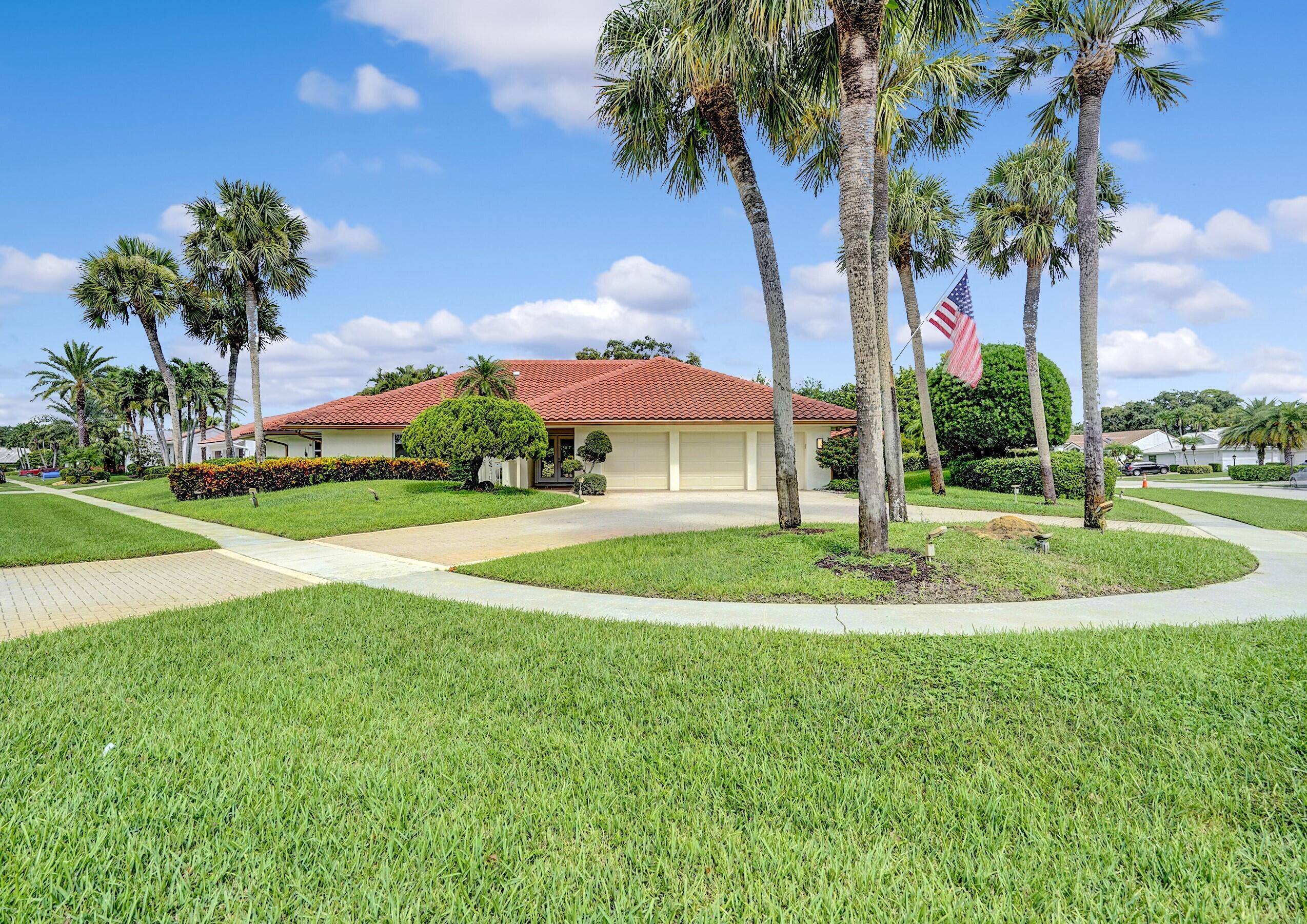 a view of a fountain in front of a house with a big yard