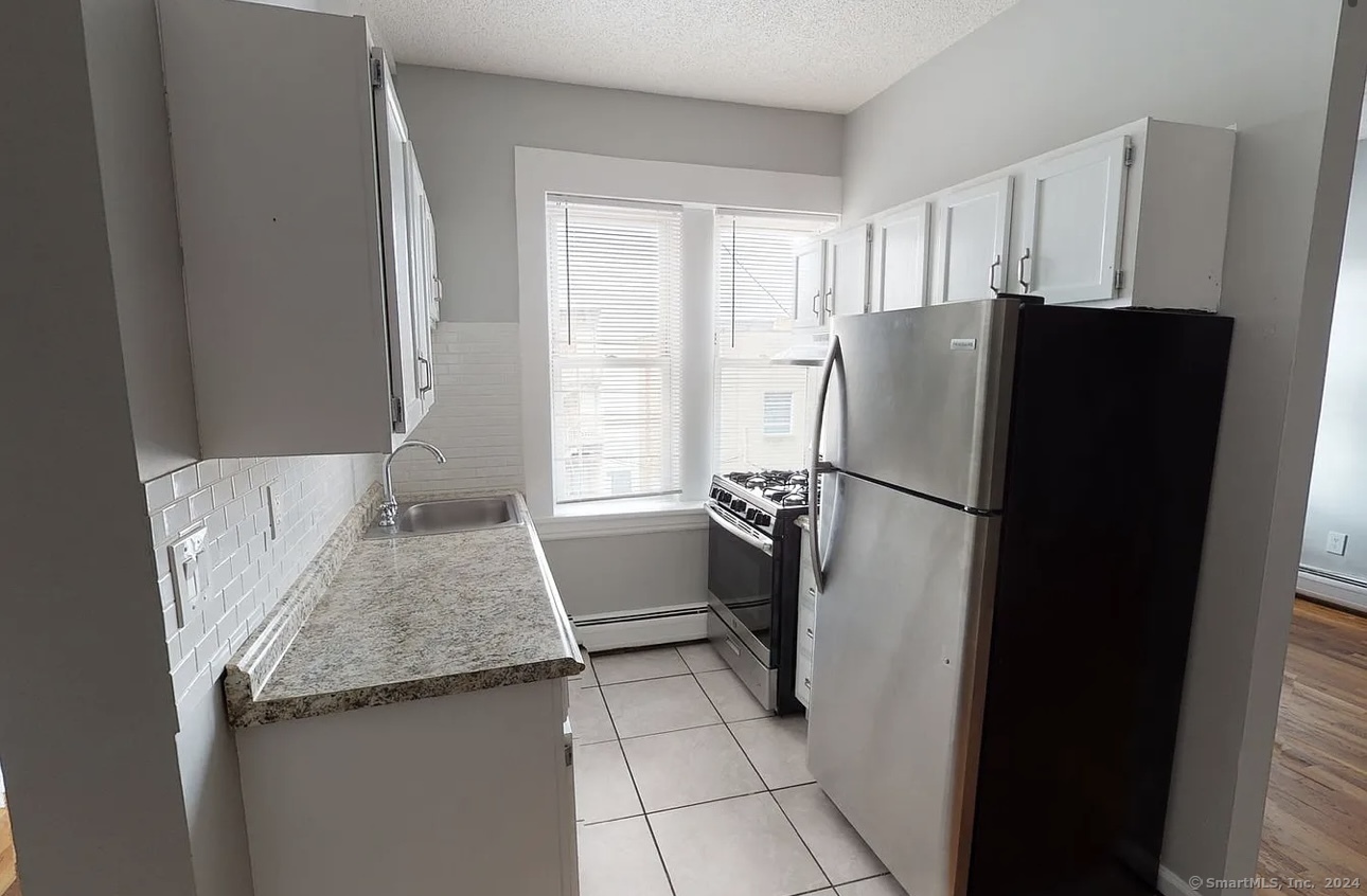 a kitchen with a refrigerator and a granite counter tops