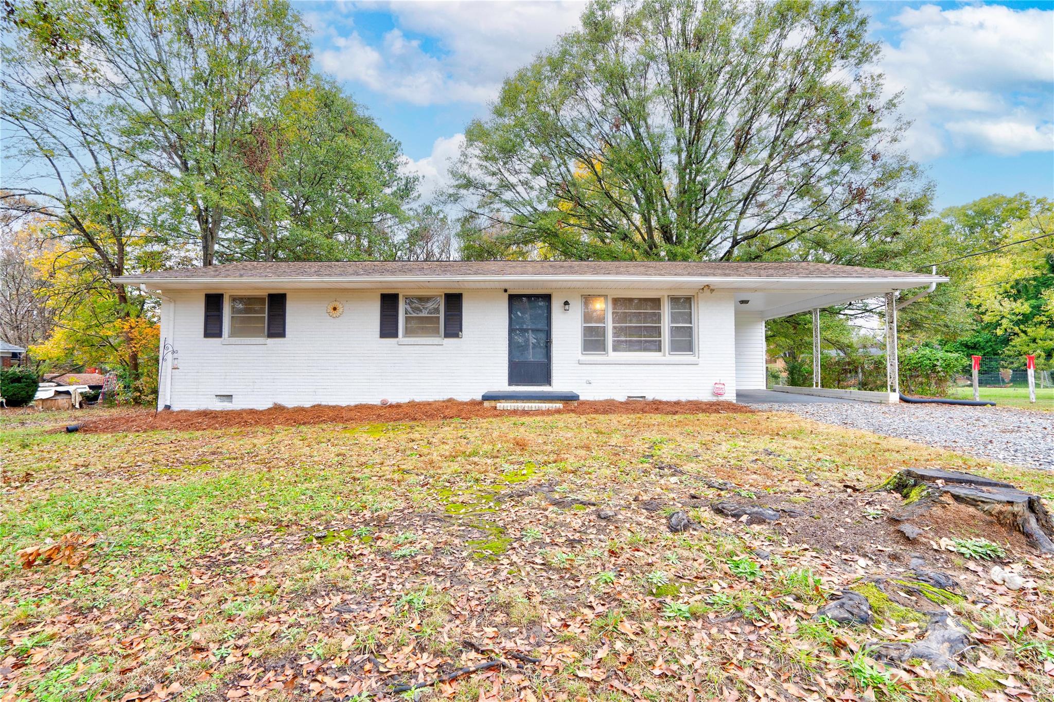 a front view of house with yard and trees around