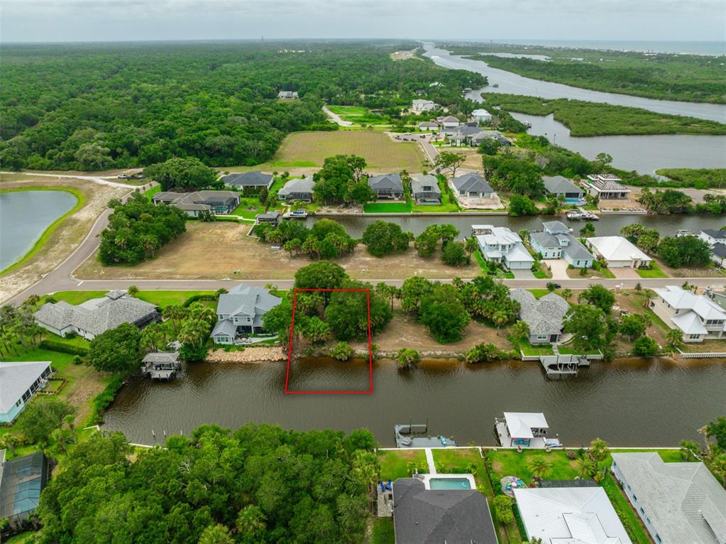 an aerial view of residential houses with outdoor space and lake view