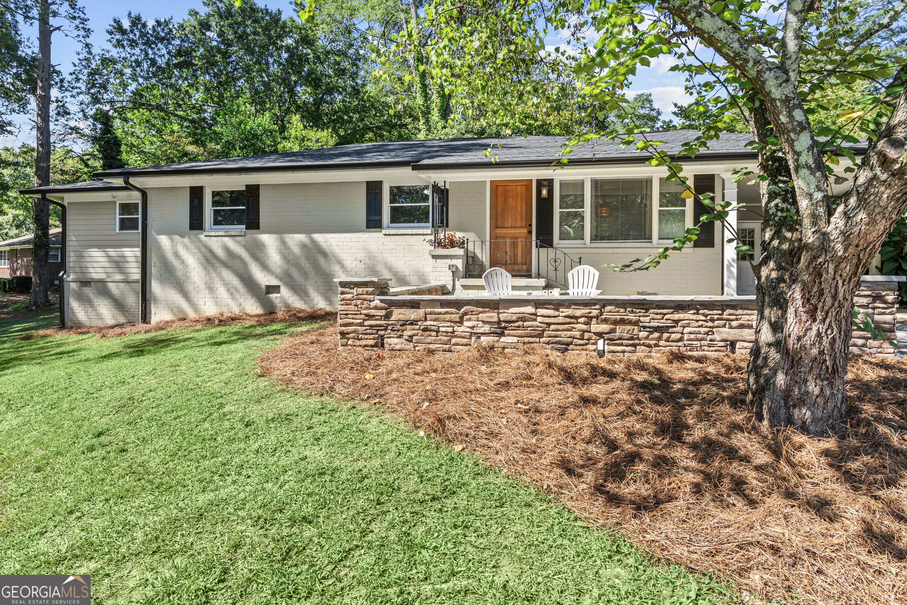 a view of house with backyard and seating area