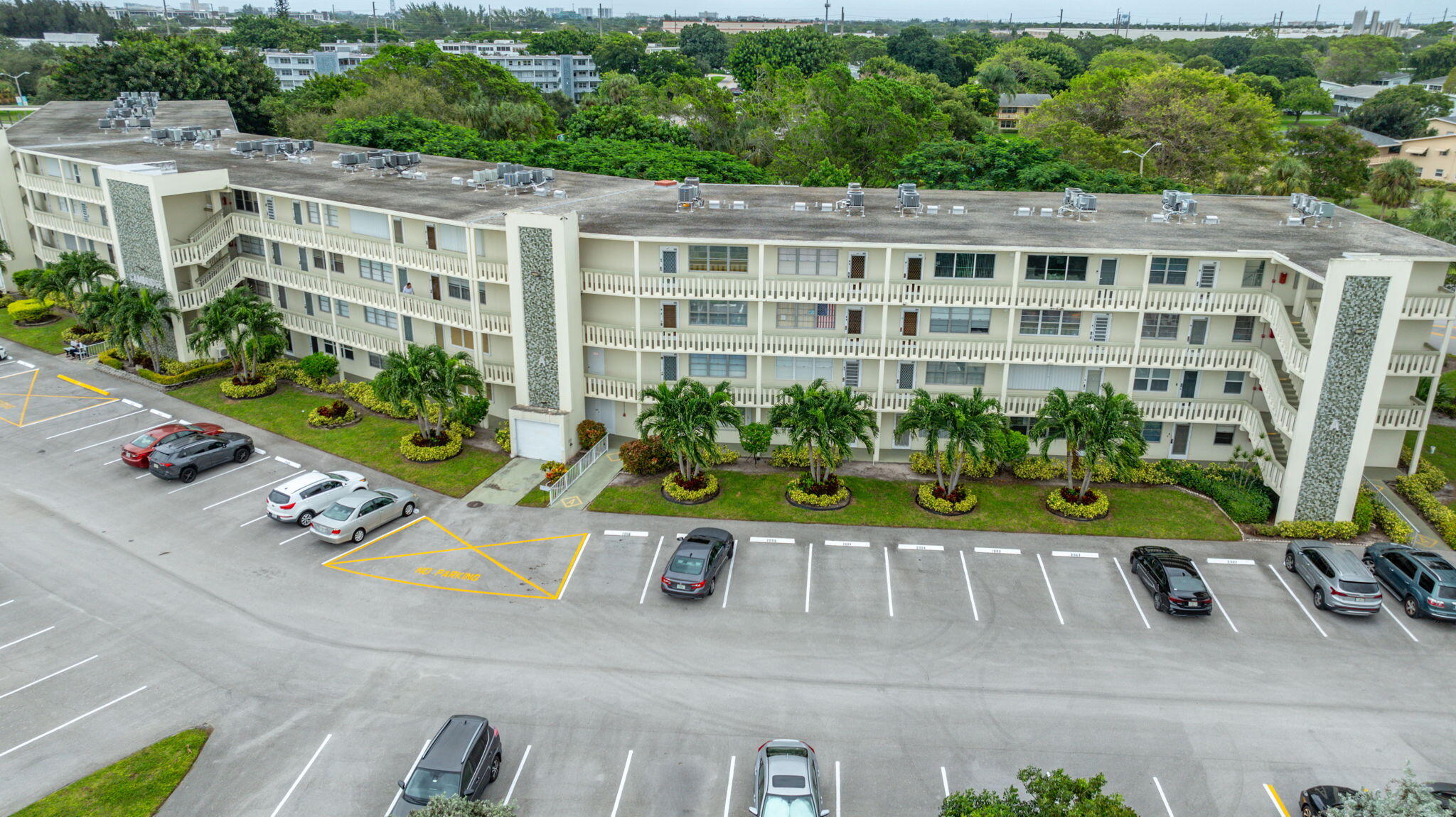 a view of a multi story residential apartment building with a yard