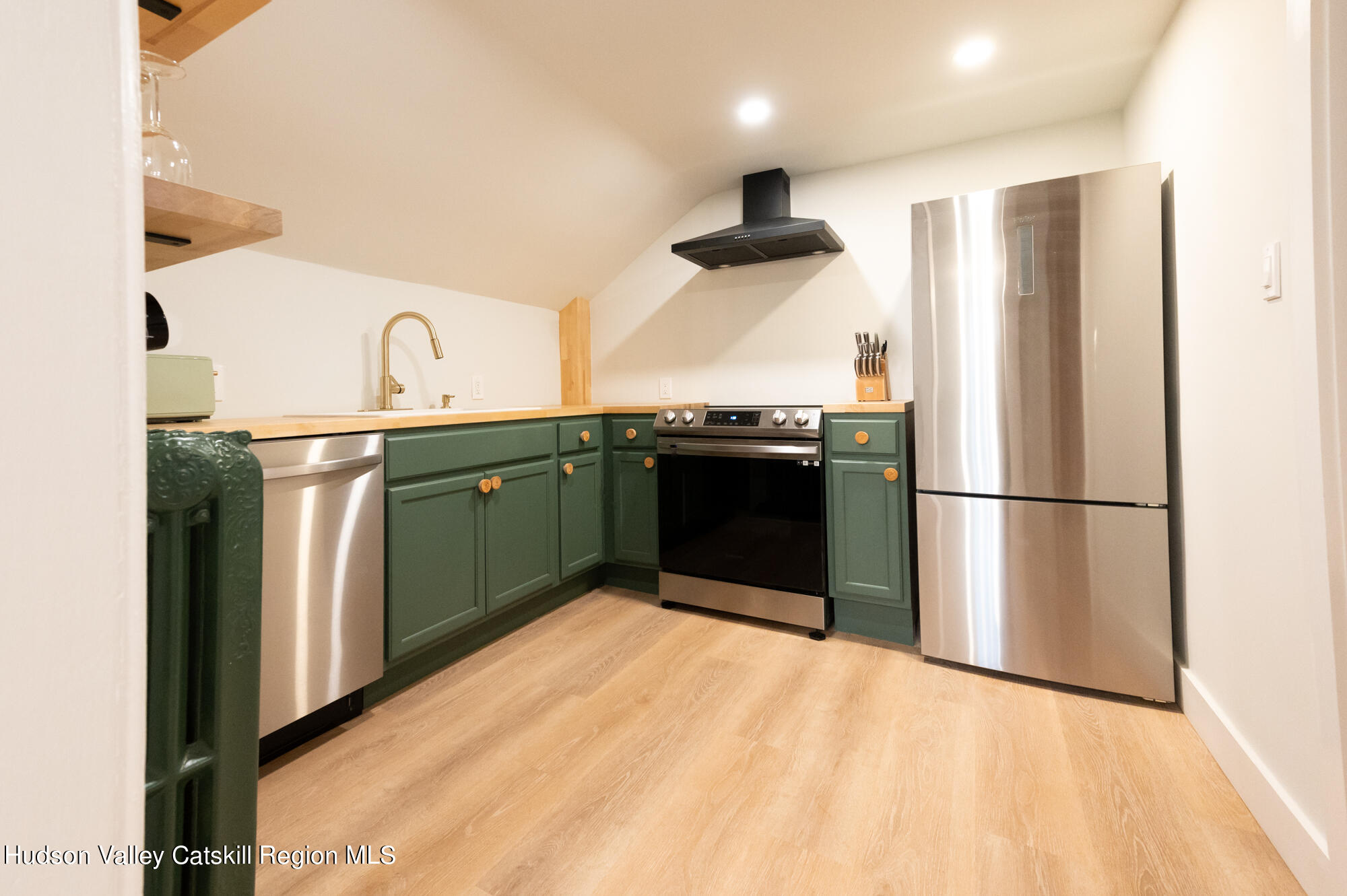 a kitchen with stainless steel appliances granite countertop a refrigerator a sink and a stove