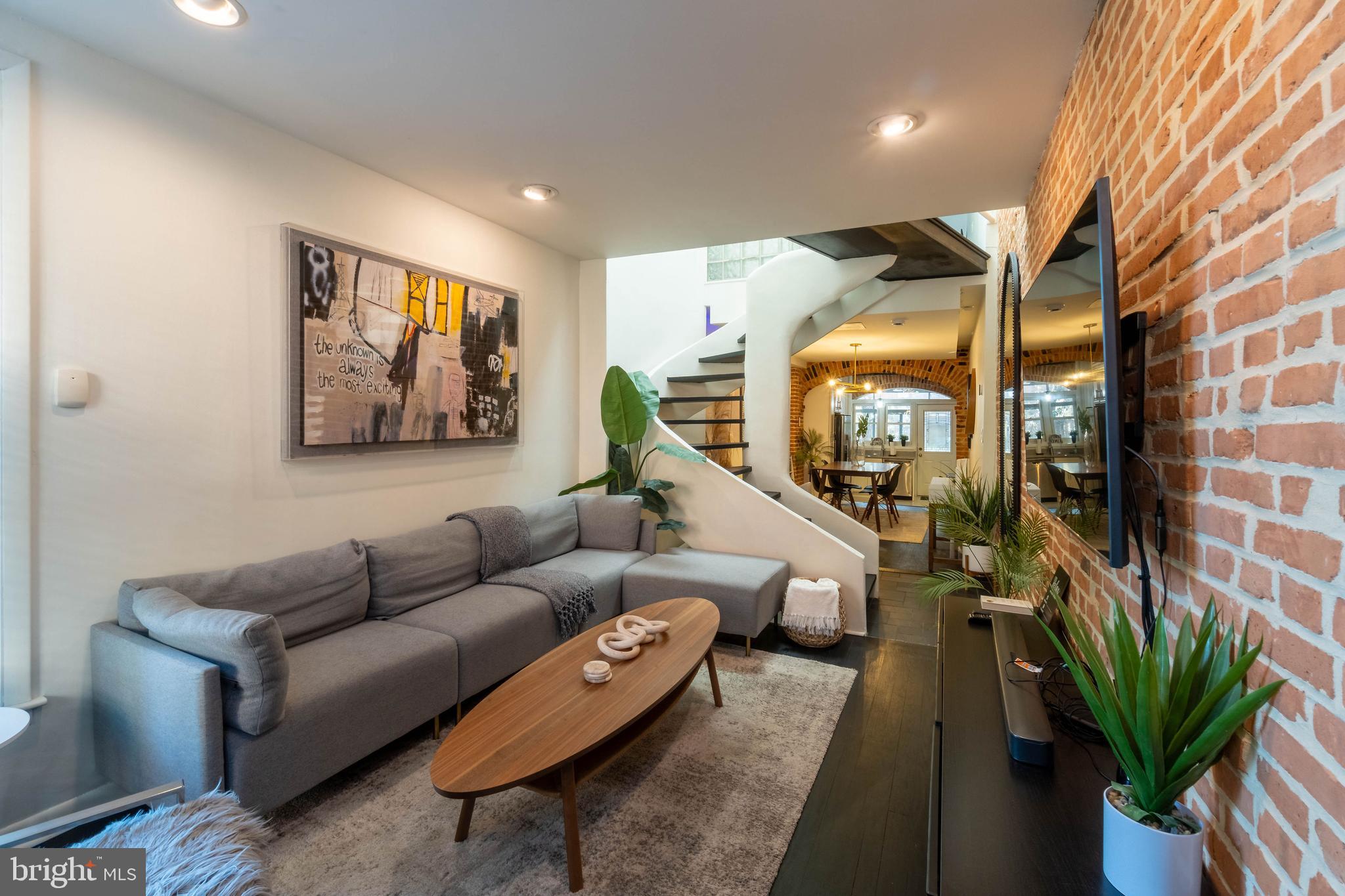 a living room with furniture a lamp and a potted plant