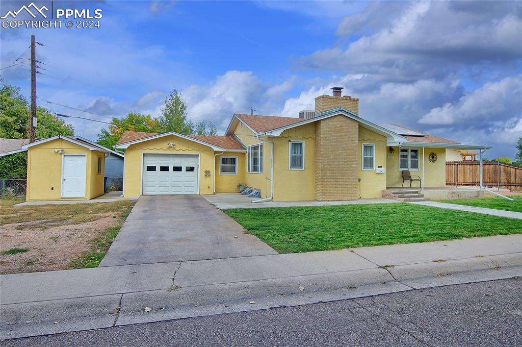 Ranch-style home with central AC unit, a front yard, and a garage