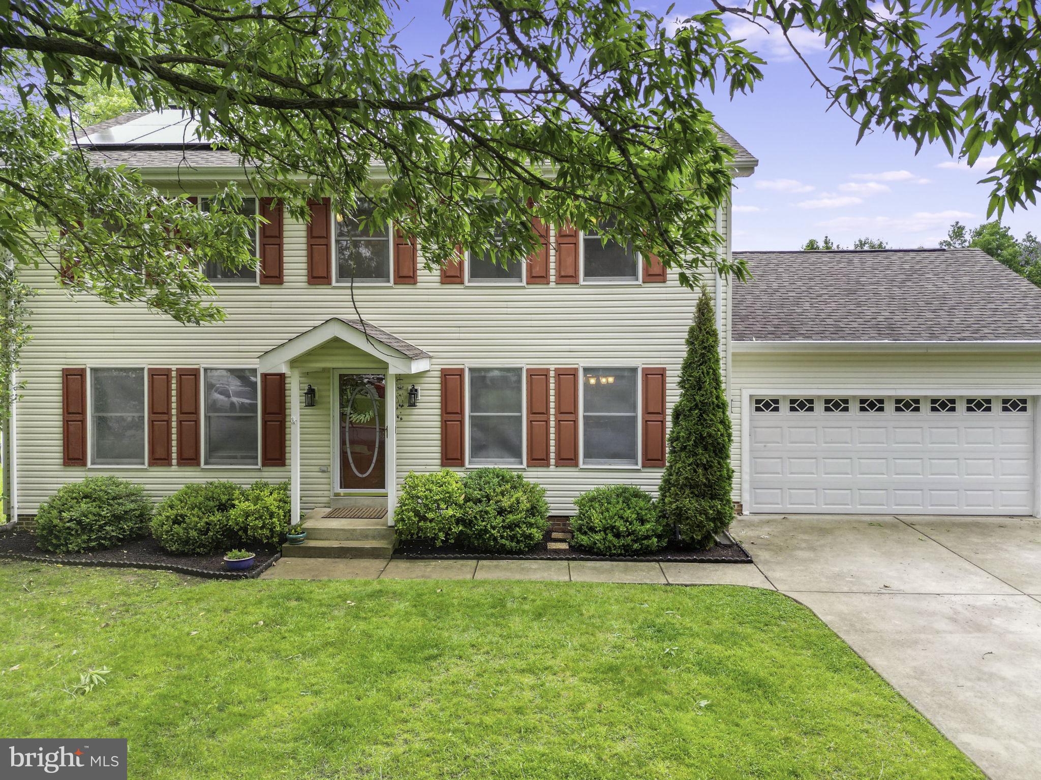 a front view of a house with a yard and trees