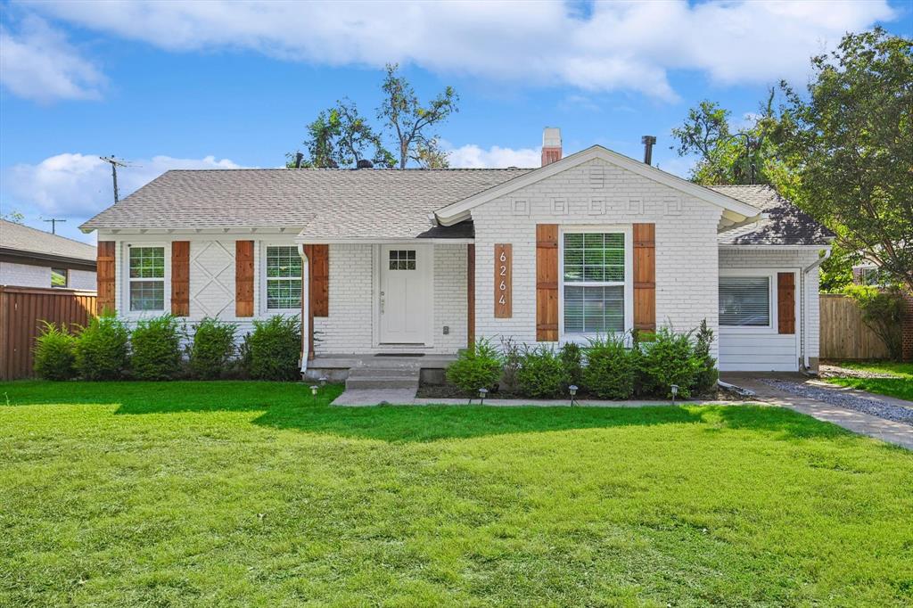 a front view of a house with garden and garage