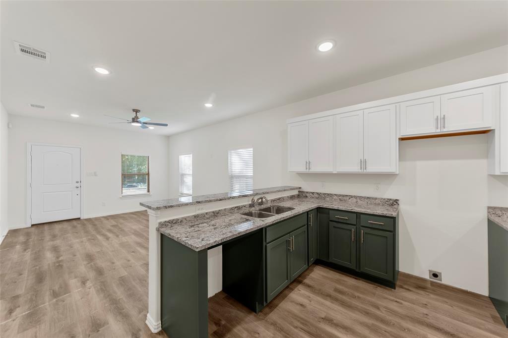 a kitchen with a sink cabinets and wooden floor