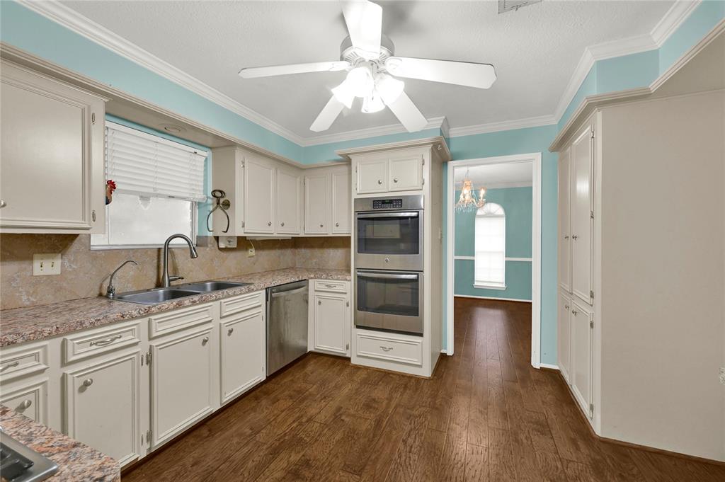 a kitchen with a sink cabinets stainless steel appliances and a window