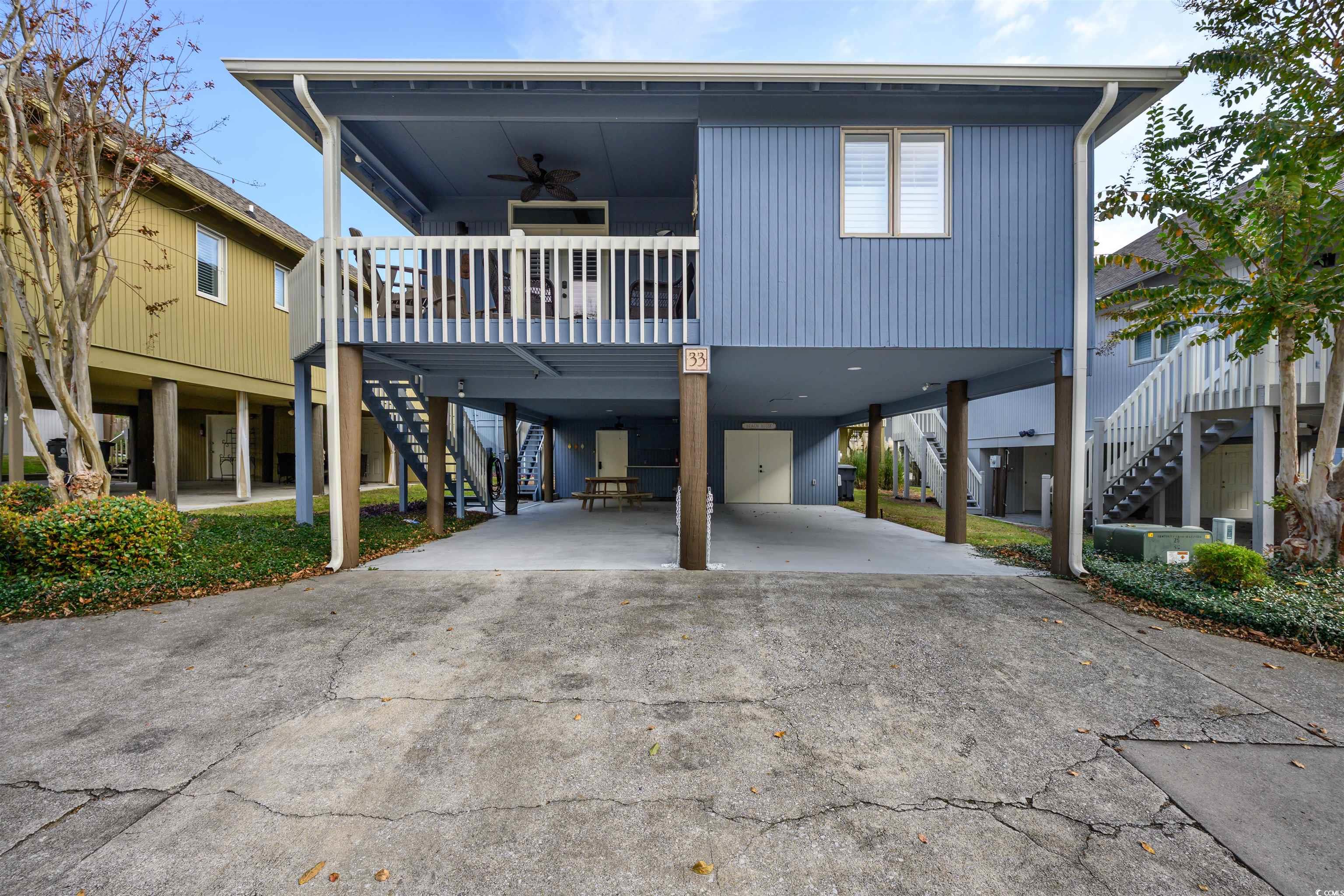 Coastal home with ceiling fan and a carport