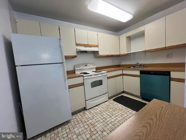 a kitchen with a refrigerator sink and cabinets