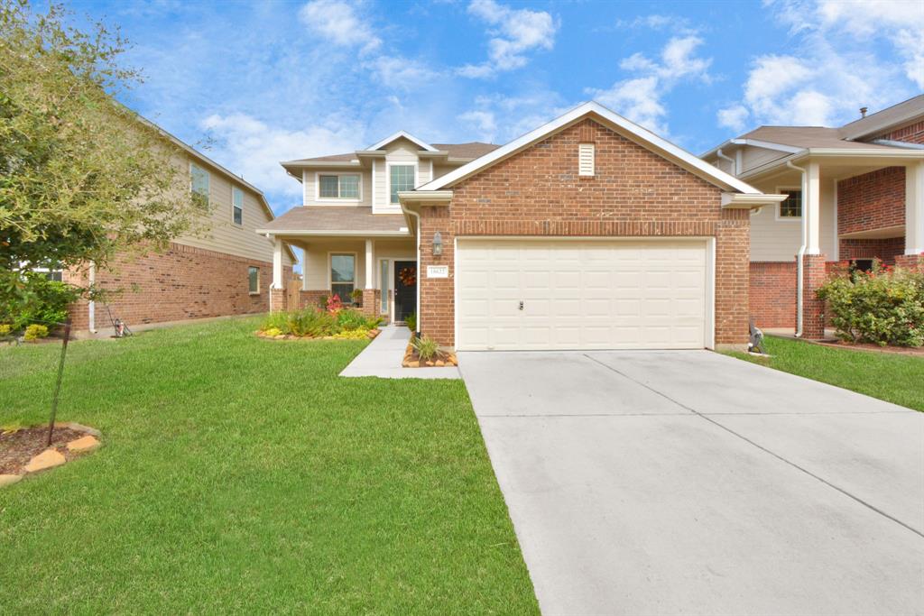 a front view of a house with a yard and garage