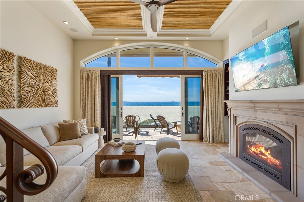 a living room with furniture a fireplace and a floor to ceiling window