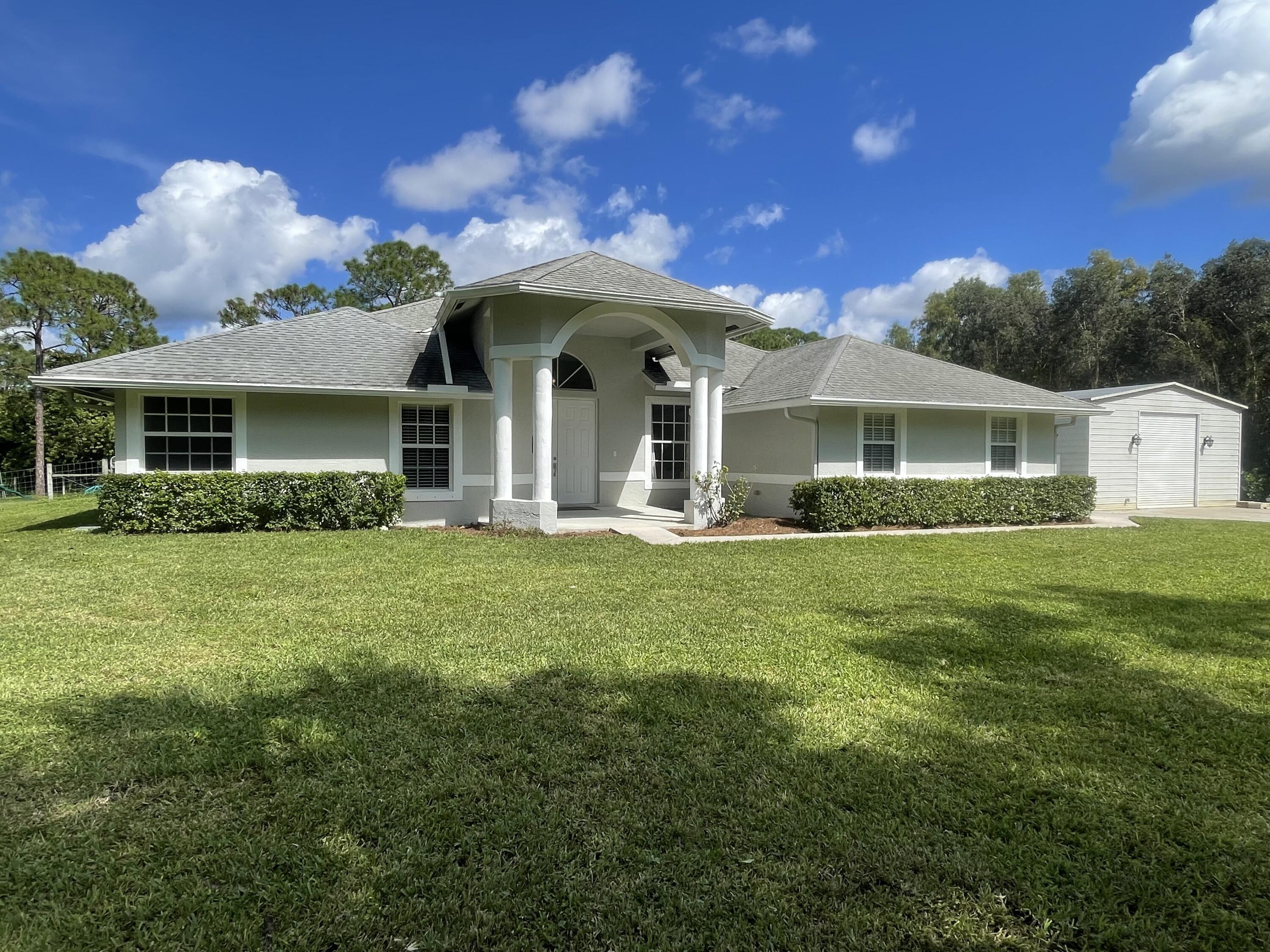 a front view of the house with yard and green space