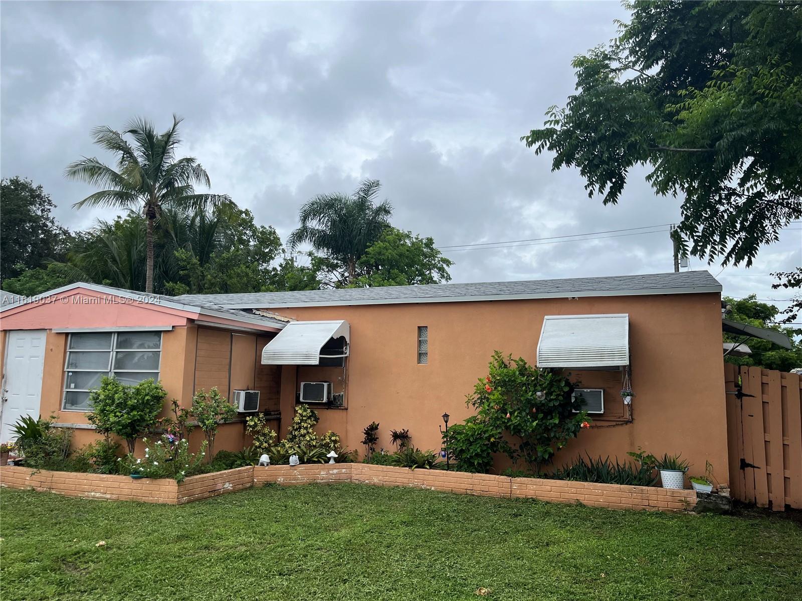 a view of house with garden and a yard