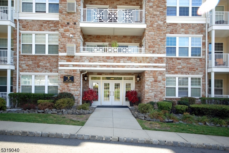 front view of a brick building with potted plants