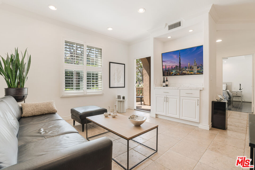 a living room with furniture a window and a flat screen tv