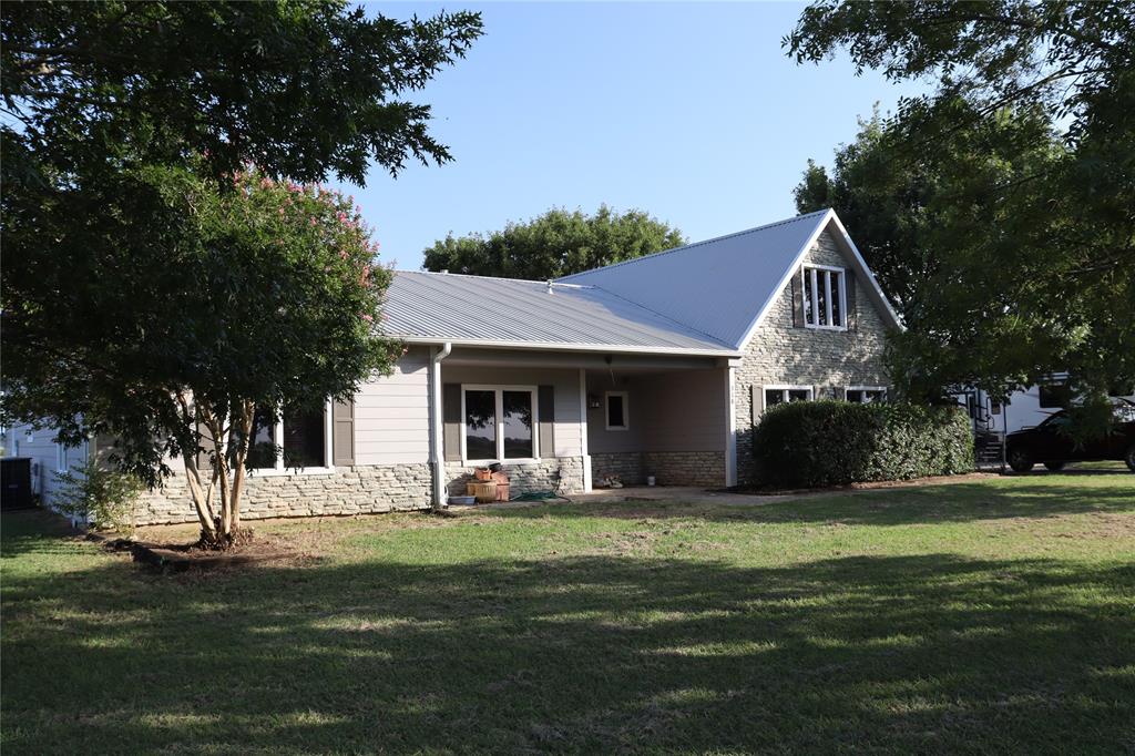 a front view of a house with a garden and trees