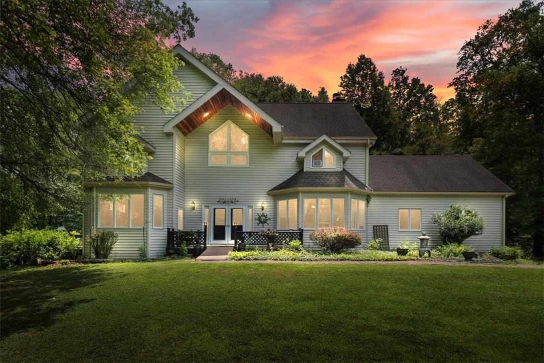 a front view of a house with a yard and trees