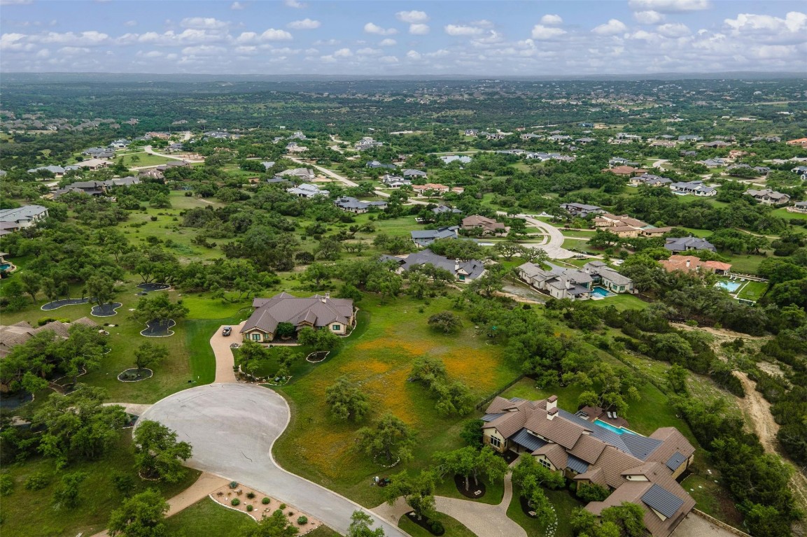 an aerial view of residential houses with outdoor space and trees