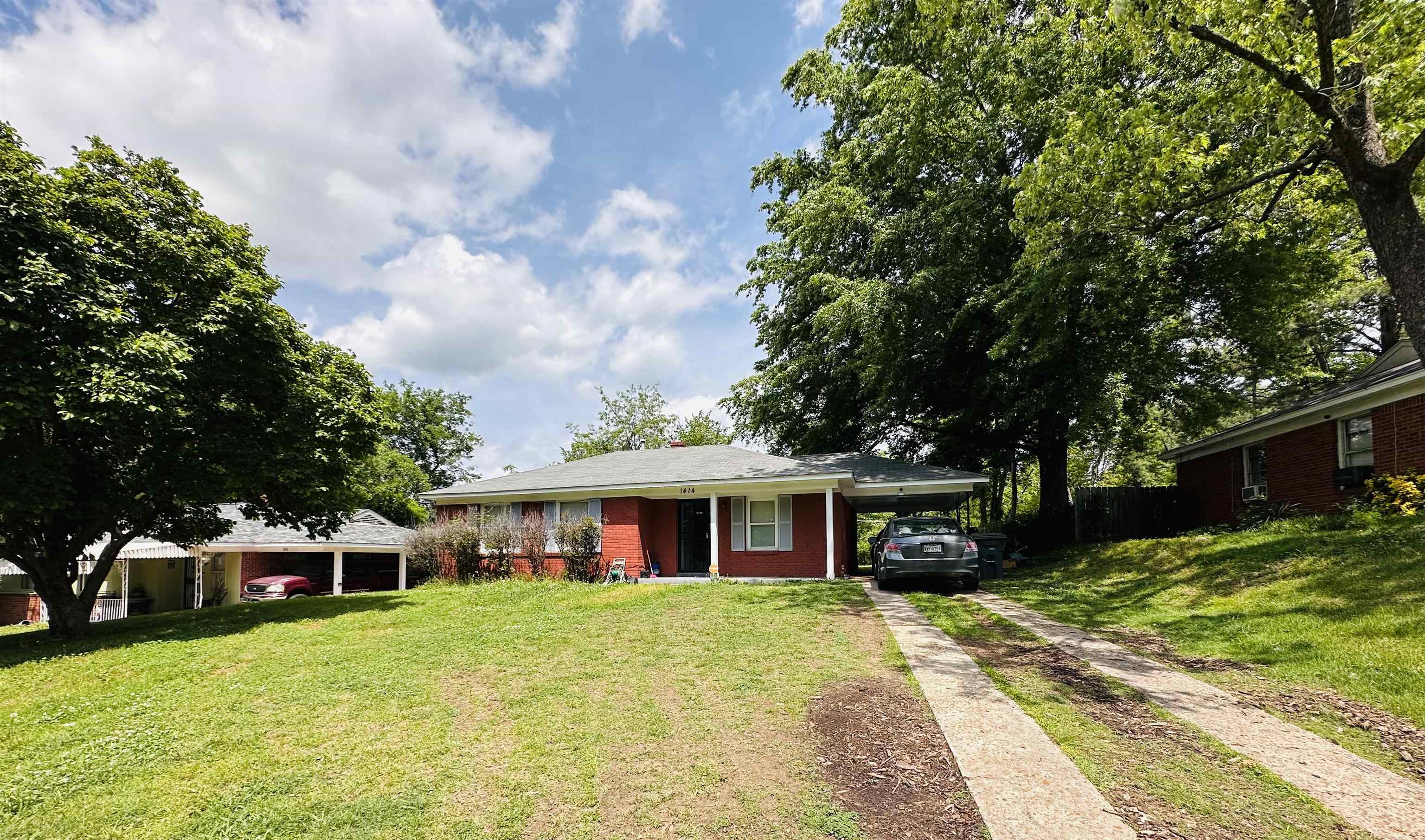 a front view of a house with a yard and trees