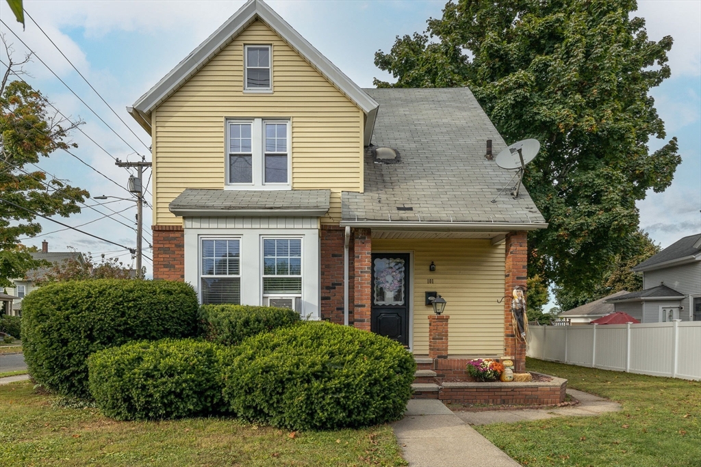 a front view of a house with a yard and potted plants