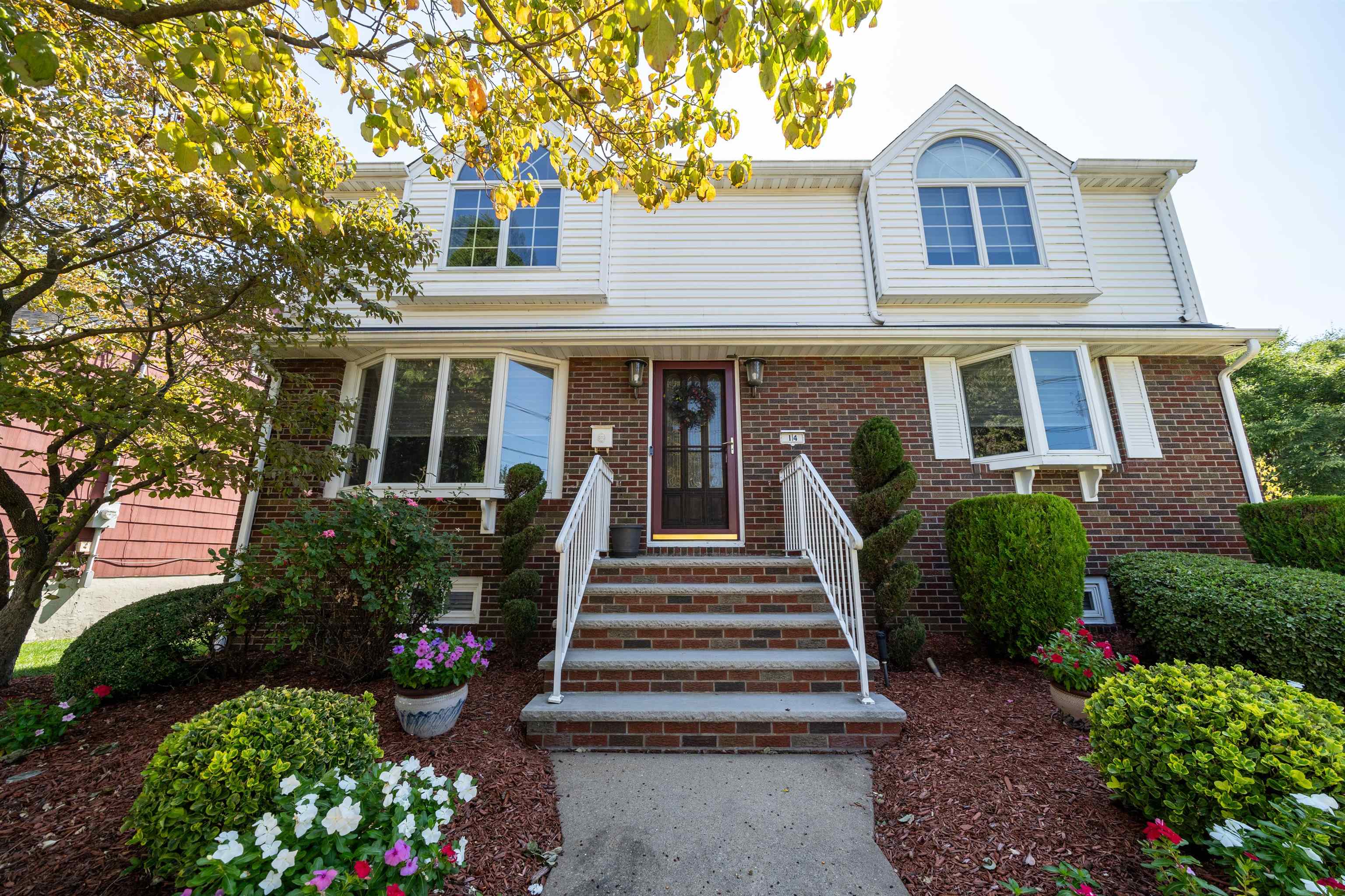 a front view of a house with a yard and potted plants